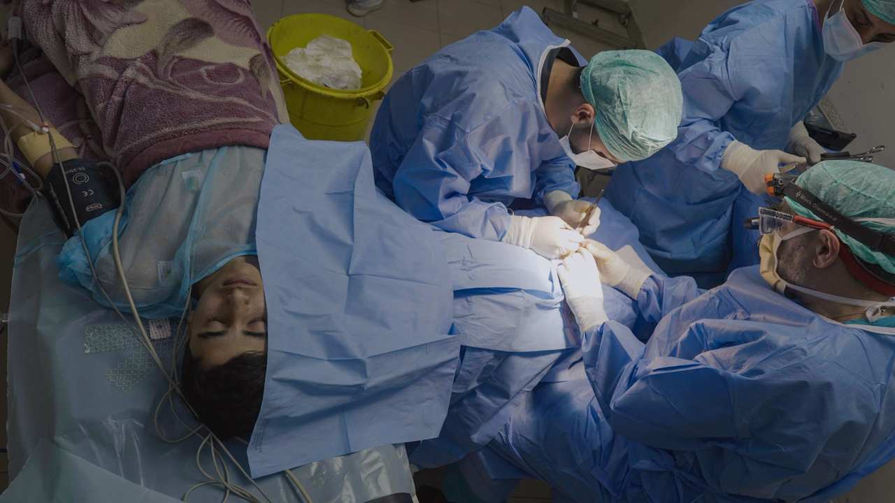 three doctors performing surgery on a man